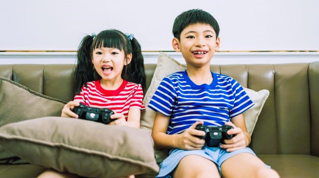 boy and girl sitting on couch playing video game